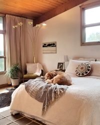 mid century modern bedroom with dog on bed house plant arch lamp